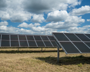 The solar panels in the grain field in the countryside under the cloudy sky